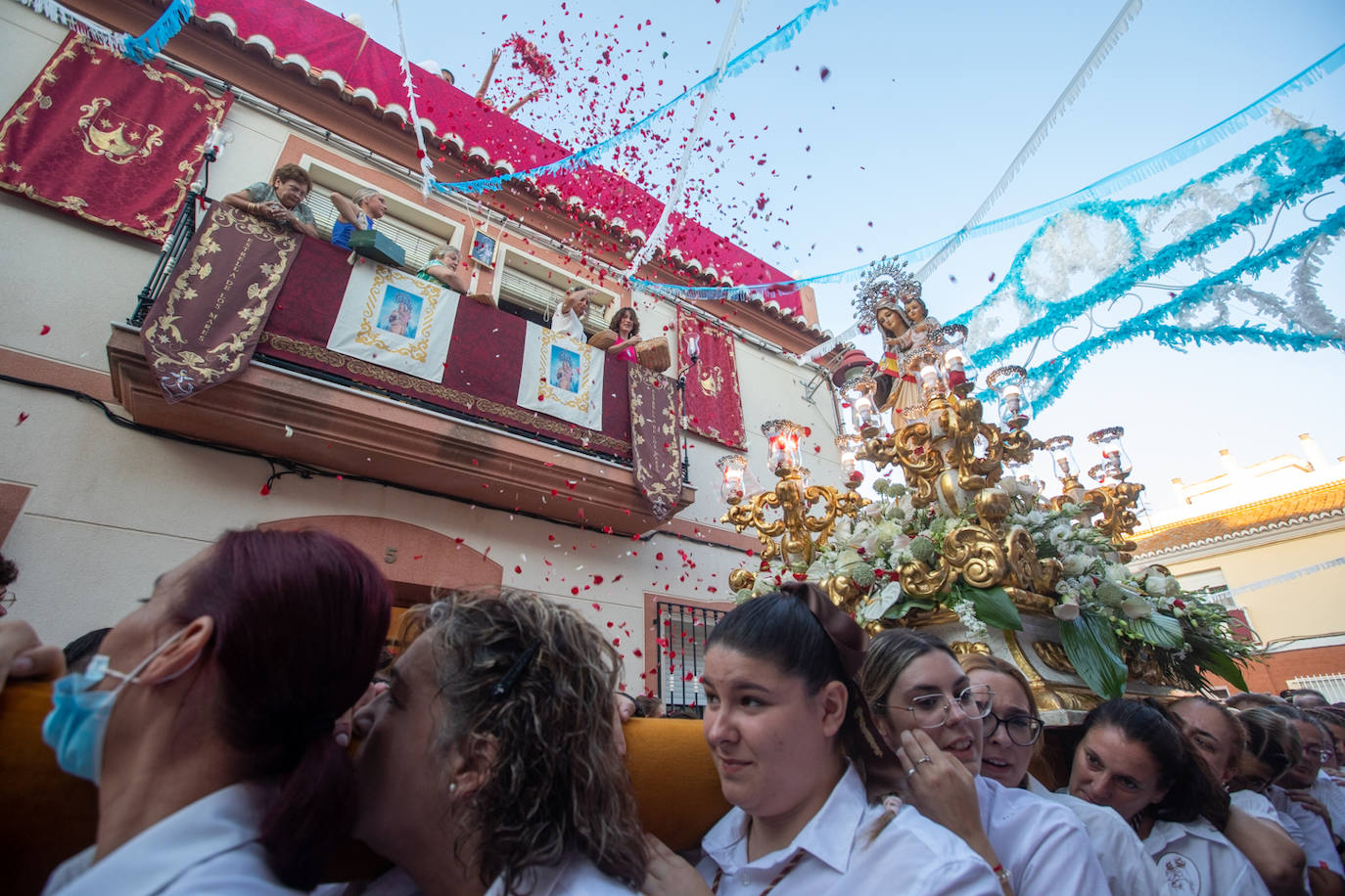 El trono de la Virgen del Carmen recibe una petalá a su paso por una de las calles de Varadero en Motril.