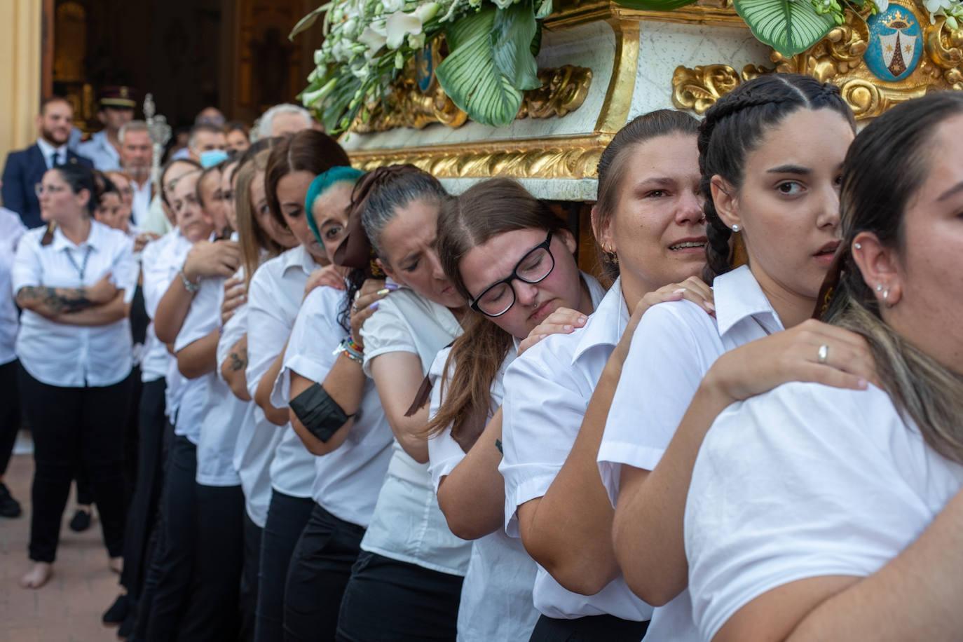 El trono de la Virgen del Carmen recibe una petalá a su paso por una de las calles de Varadero en Motril.