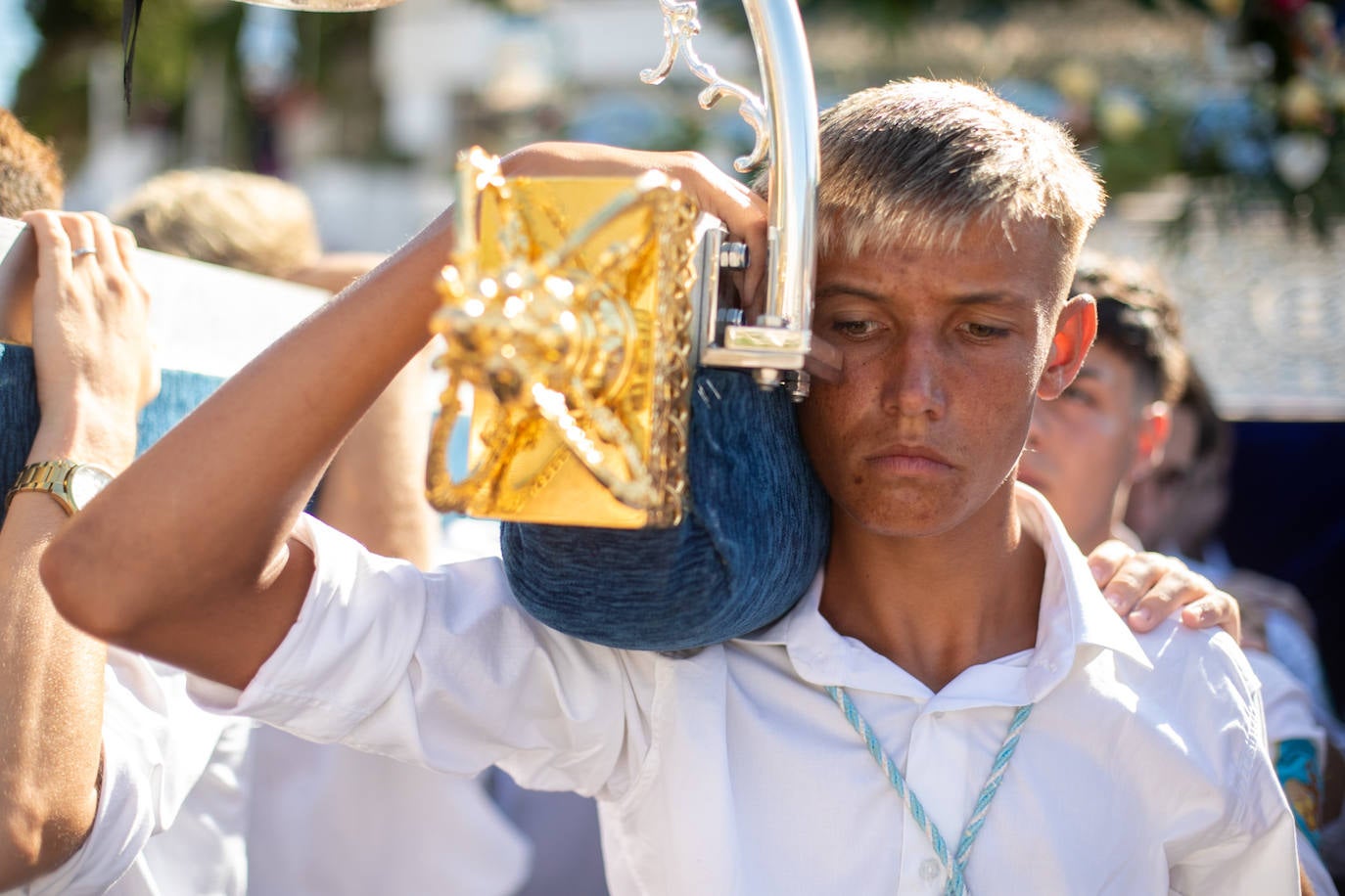 La Virgen del Carmen de Almuñéca, con el Barrio de Los Marinos al fondo, enfila la playa de San Cristóbal tras salir de la capilla.