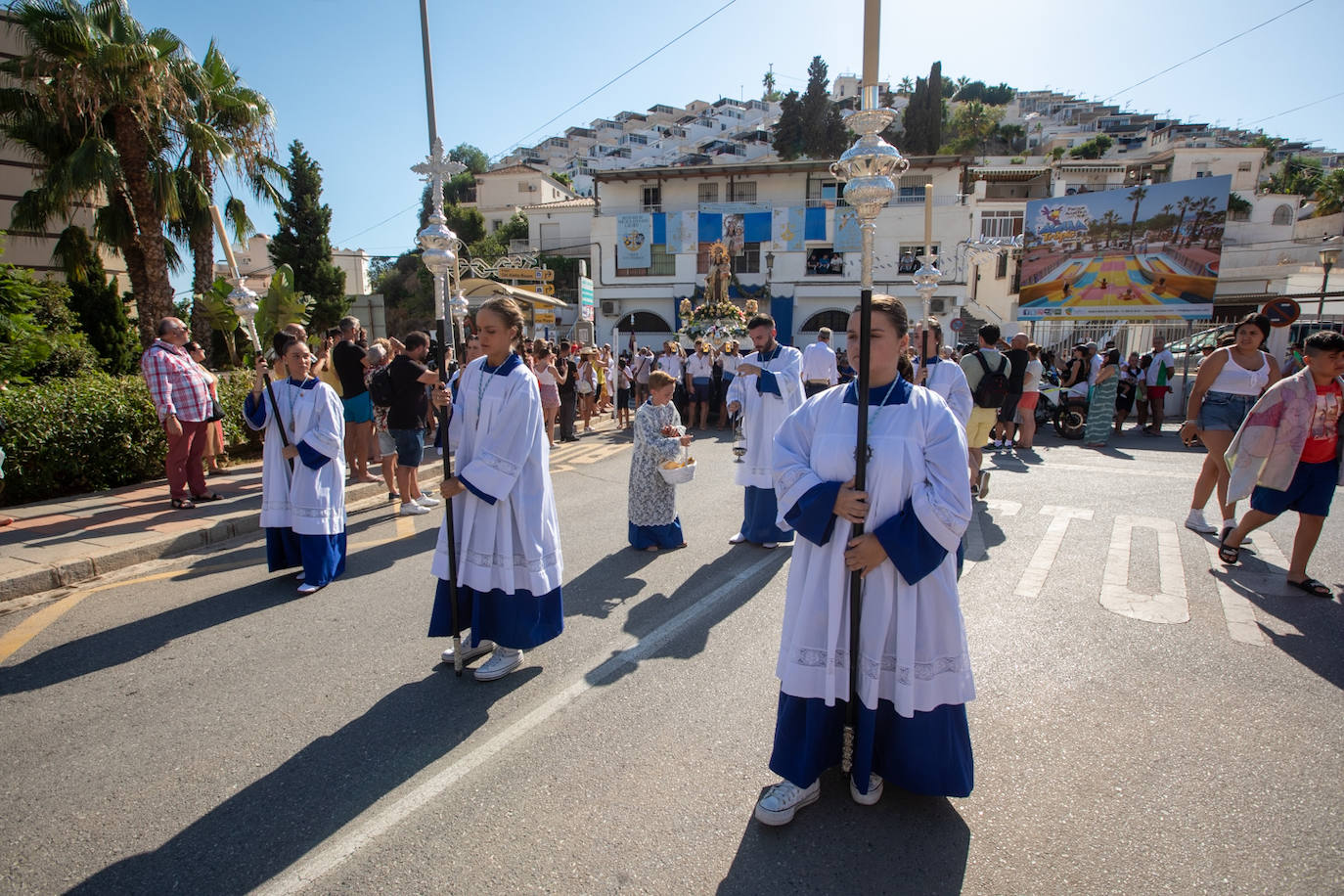 La Virgen del Carmen de Almuñéca, con el Barrio de Los Marinos al fondo, enfila la playa de San Cristóbal tras salir de la capilla.