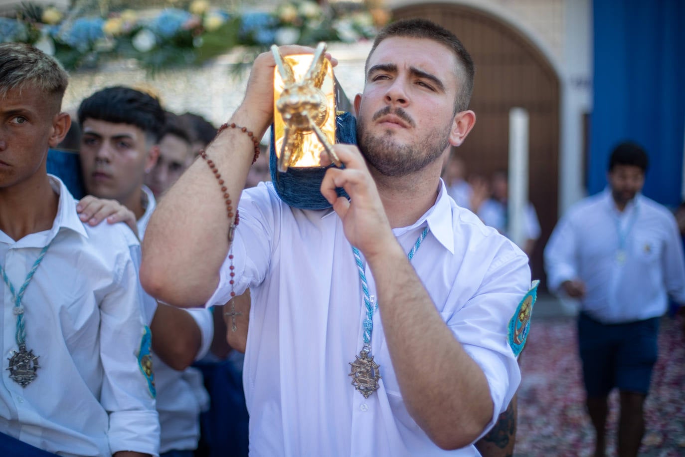 La Virgen del Carmen de Almuñéca, con el Barrio de Los Marinos al fondo, enfila la playa de San Cristóbal tras salir de la capilla.