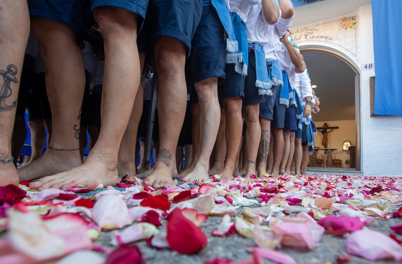 La Virgen del Carmen de Almuñéca, con el Barrio de Los Marinos al fondo, enfila la playa de San Cristóbal tras salir de la capilla.