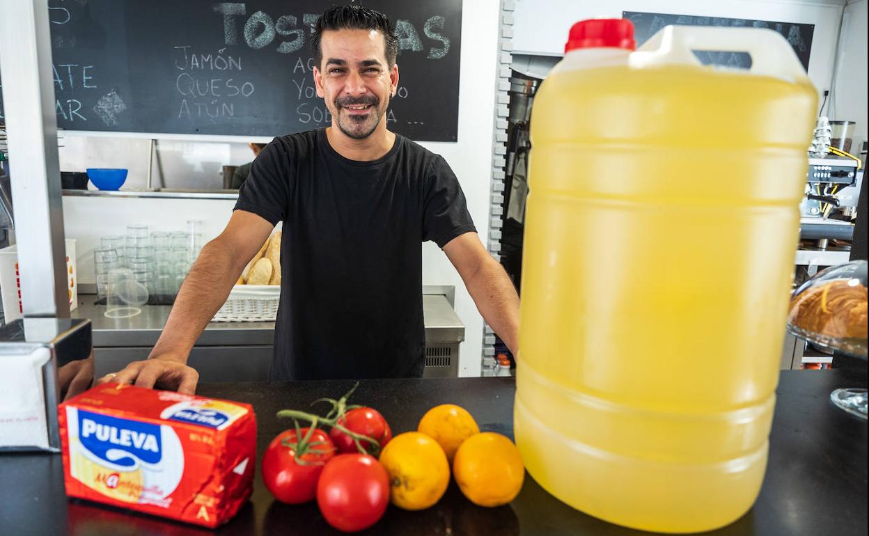 Jonathan de la Osa posa para IDEAL en su cafetería con una garrafa de 25 litros de aceite de girasol, mantequilla, tomate y naranjas. 