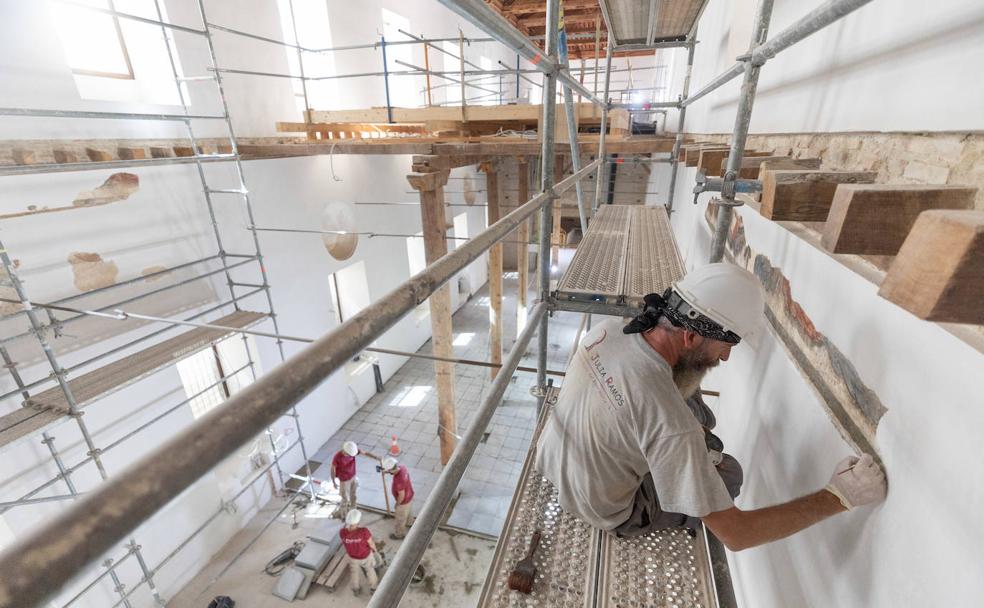 En primer término, un trabajador trabaja en el proceso de limpieza de pinturas al fresco de la capilla. 