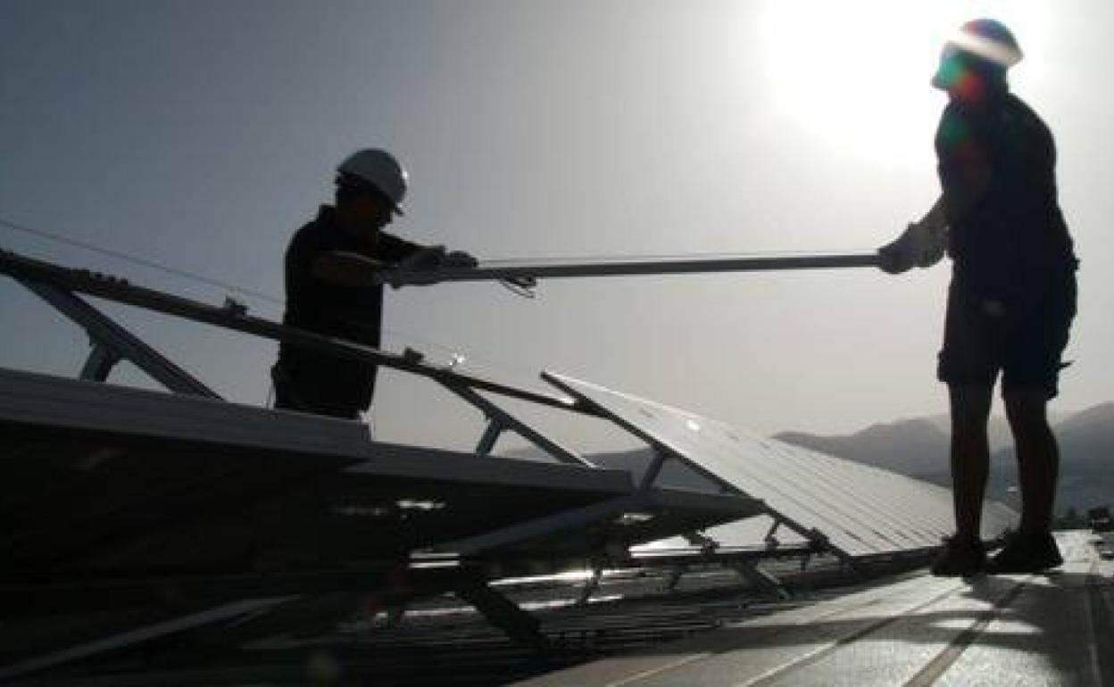 Técnicos especialistas instalando placas solares. 