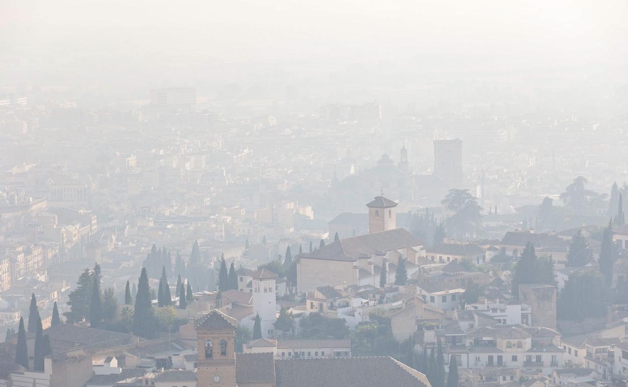 El Centro de Granada y parte del Albaicin cubierto de una neblina de humo visto desde el Cerro de San Miguel.
