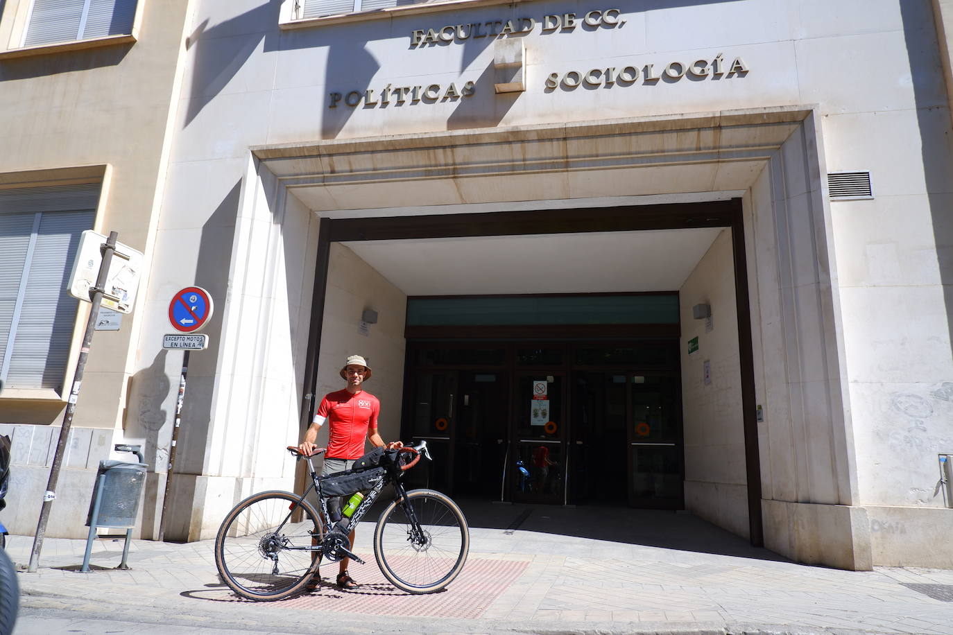 El estudiante Amedeo Girardi posa con su bicicleta frente a la Facultad de Ciencias Políticas de la UGR.