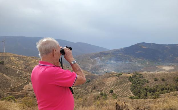 Valverde, vecino de Lanjarón, observa con los prismáticos la zona quemada en El Pinar