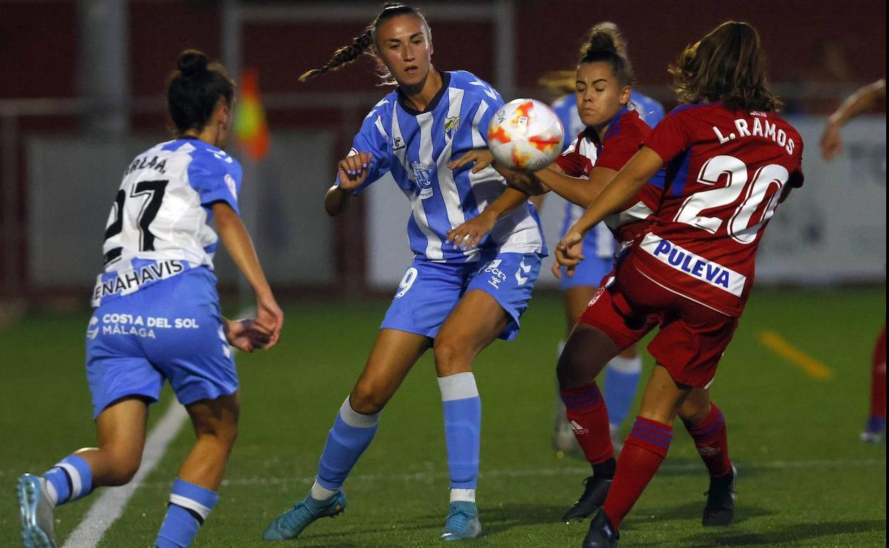 Lucía Ramos y Carol pelean un balón con dos jugadoras locales. 