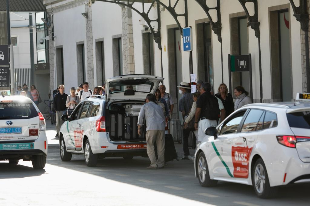 Viajeros suben a un taxi en la estación de tren de Granada. 