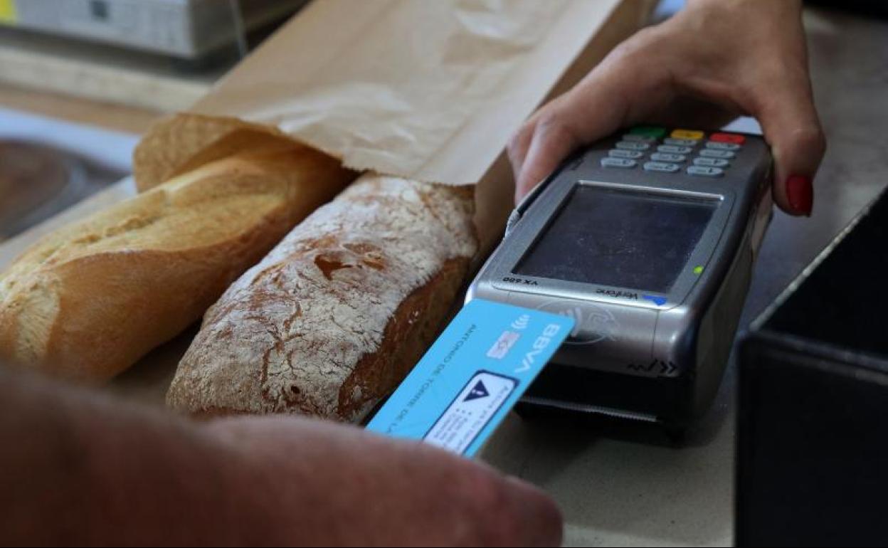 Un cliente paga con una tarjeta bancaria en une establecimiento