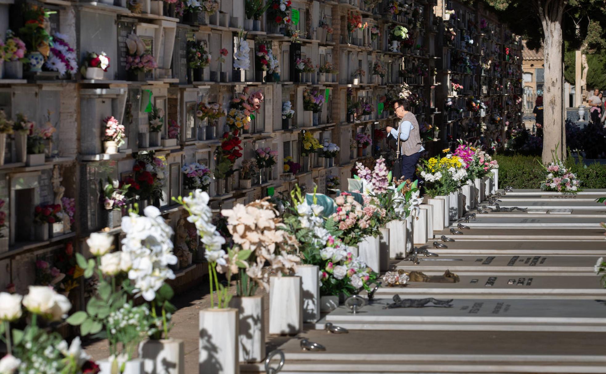 Una mujer adecenta un nicho esta mañana en uno de los patios del Cementerio. 