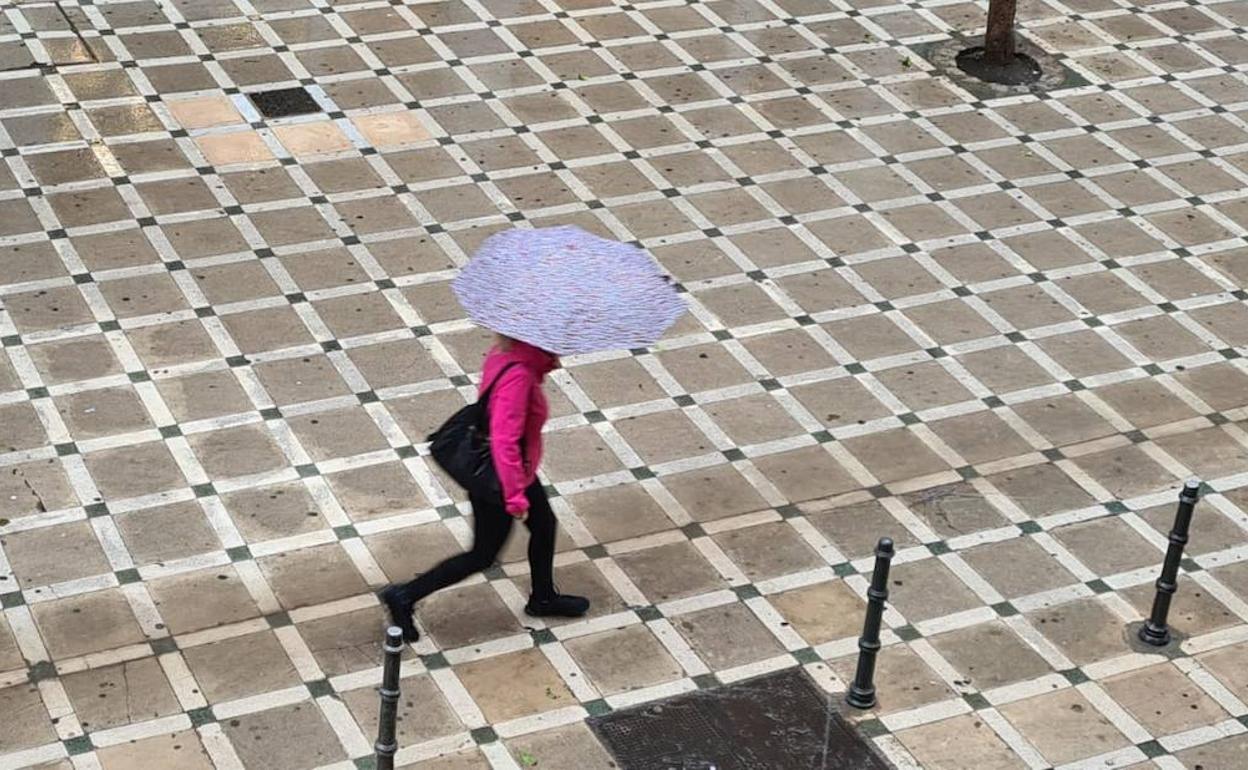 Una mujer con un paraguas en la calle Navas de Tolosa de la capital. 