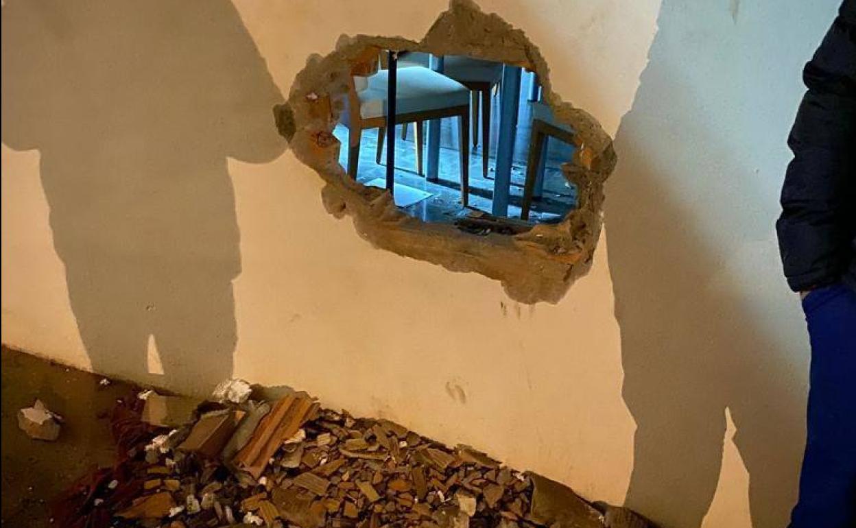 Butrón por el que entraron los ladrones al local asaltado en Las Gabias.