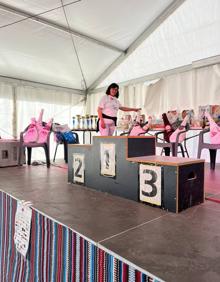Imagen secundaria 2 - Integrantes de la asociación de mujeres los Tres Barrios de Trevélez. Dos corredores cruzan la meta. El podio con todos los premios que se han repartido a los participantes tras la carrera. 