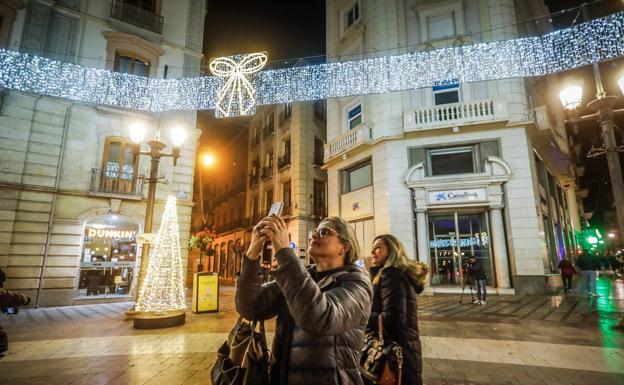 Una mujer fotografía el alumbrado de Navidad.