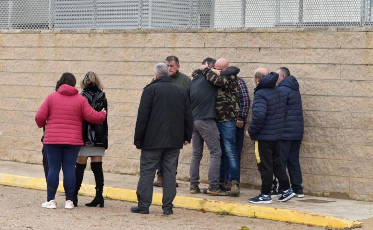 El padre de las niñas fallecidas (chaqueta azul marino) se abraza en la entrada del cuartel de la Guardia Civil.