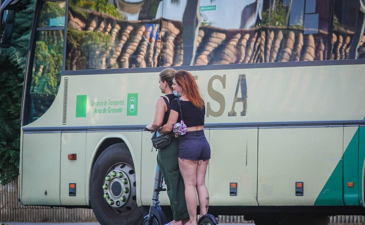 Dos personas circulan en un patinete eléctrico sin casco.