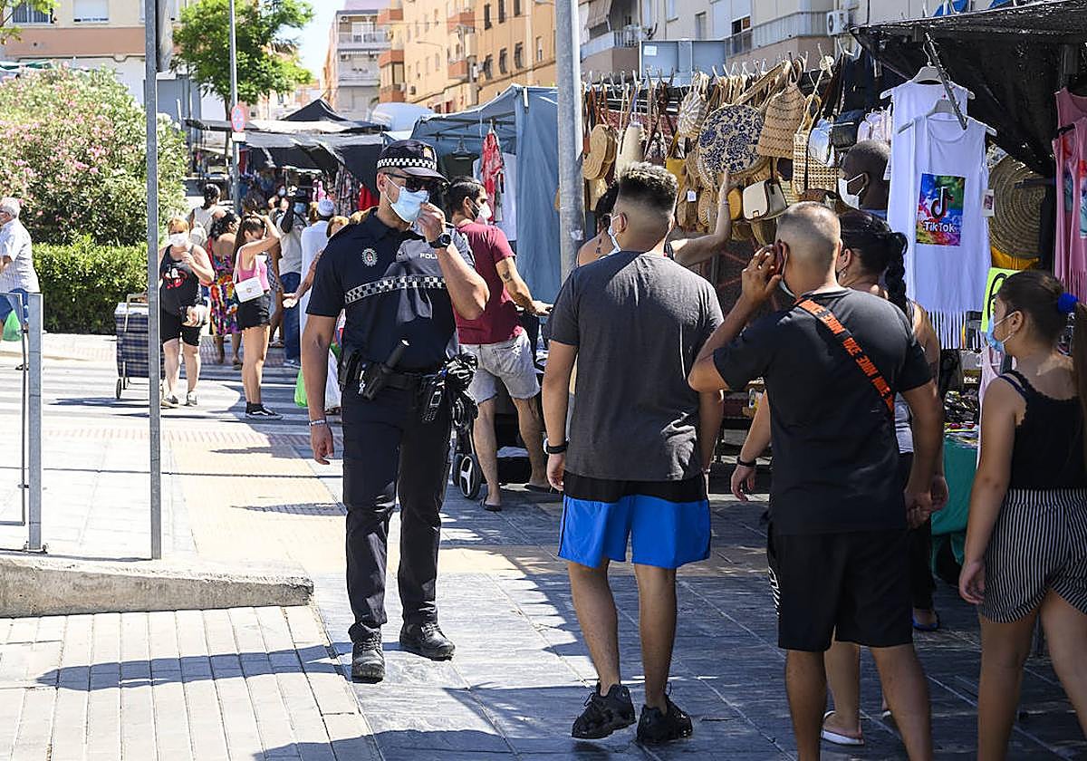 Un agente de la Policía Local recordando la obligatoriedad de usar mascarilla en las calles de Almería.