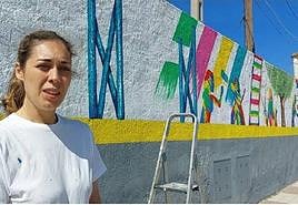 La pintora bailenense ante parte del mural.