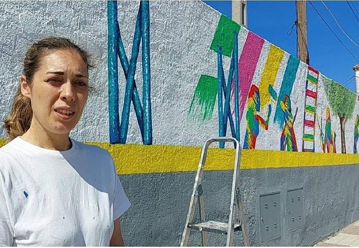 La pintora bailenense ante parte del mural.