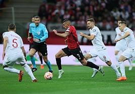 Myrto Uzuni conduce el balón perseguido por varios futbolistas polacos.