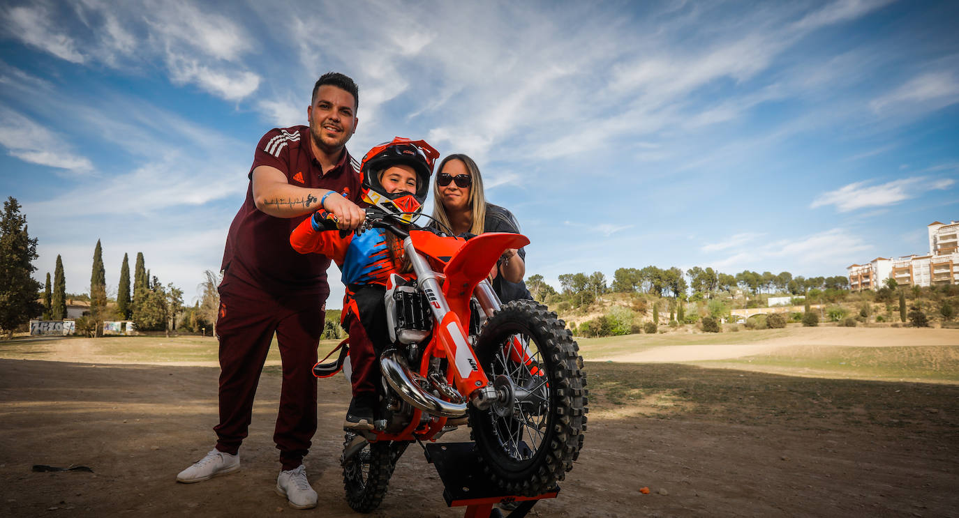 Daniela posa con su KTM60 cc de dos tiempos, junto a sus padres. Él, Iván, hace las labores del técnico.