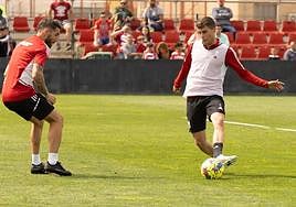 Alberto Soro juega un balón en un entrenamiento ante Alberto Perea.