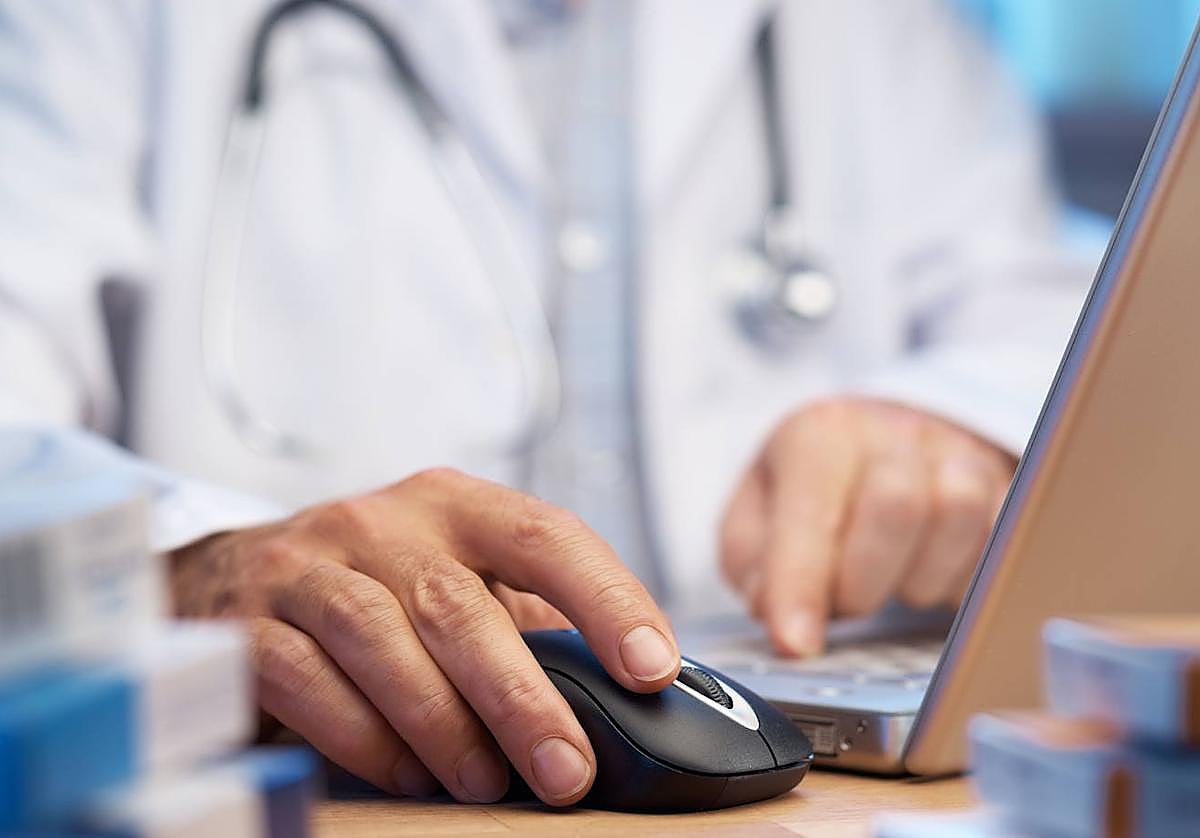 Foto de archivo de un médico atendiendo en consulta.