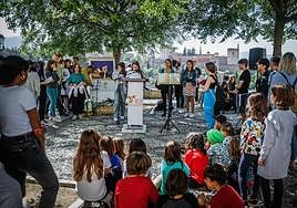 Una alumna lee un fragmento de 'El Quijote', rodeada por sus compañeros del IES Albaicín, en el Mirador de San Nicolás