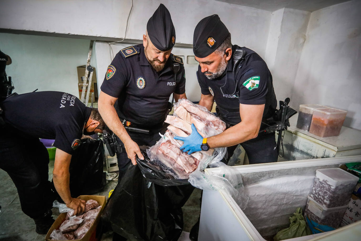 Agentes de la Policía Local de Granada retiran comida en mal estado de un restaurante de la calle Elvira