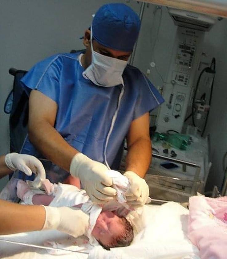 Omar con su tercera hija recién nacida.