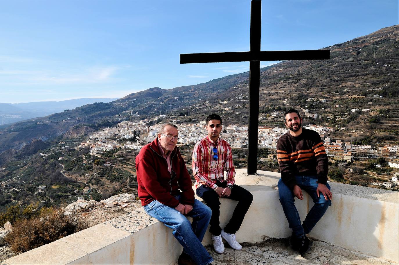 Tres vecinos junto a la cruz de la ermita.