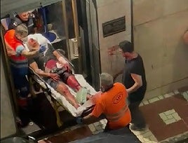 Momento en que uno de los heridos es sacado del pub por los servicios sanitarios.