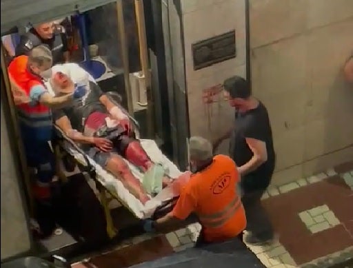 Momento en que uno de los heridos es sacado del pub por los servicios sanitarios.