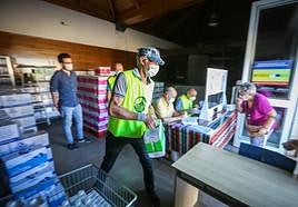 Un voluntario apila comida en uno de los almacenes de Banco de Alimentos.