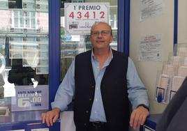 Enrique Torres en su administración posa ante el cartel con el número premiado.