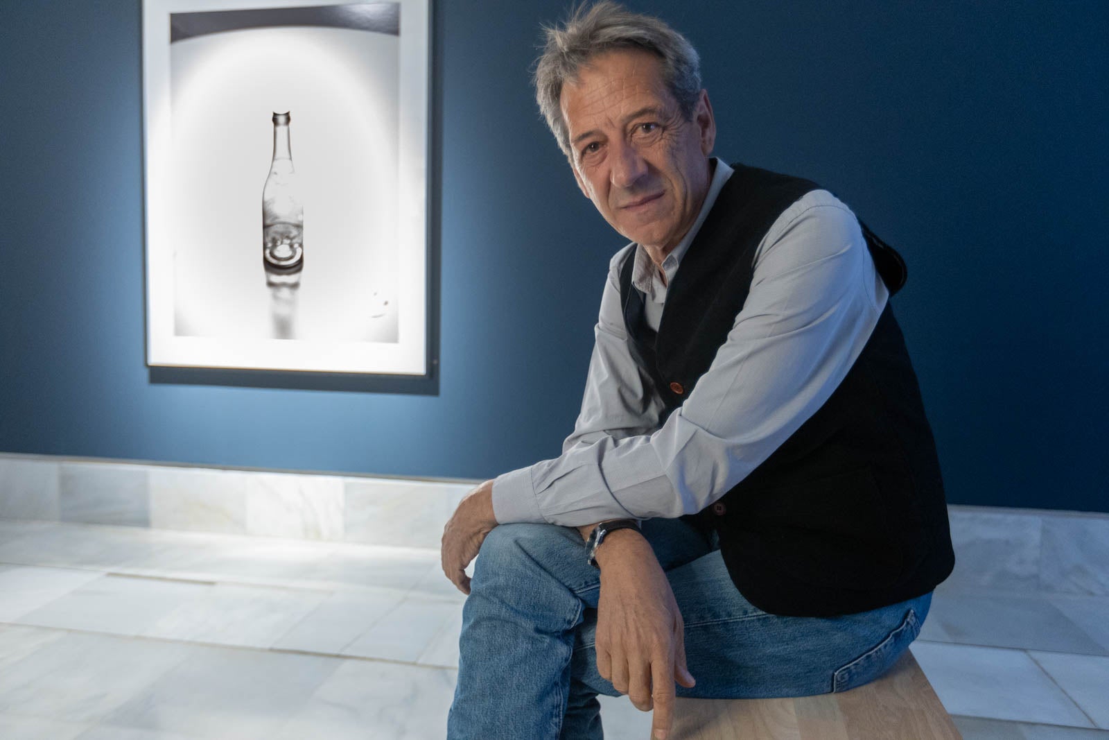 Madoz junto a la obra que ha realizado ex profeso para la exposición con un botellín de Alhambra.