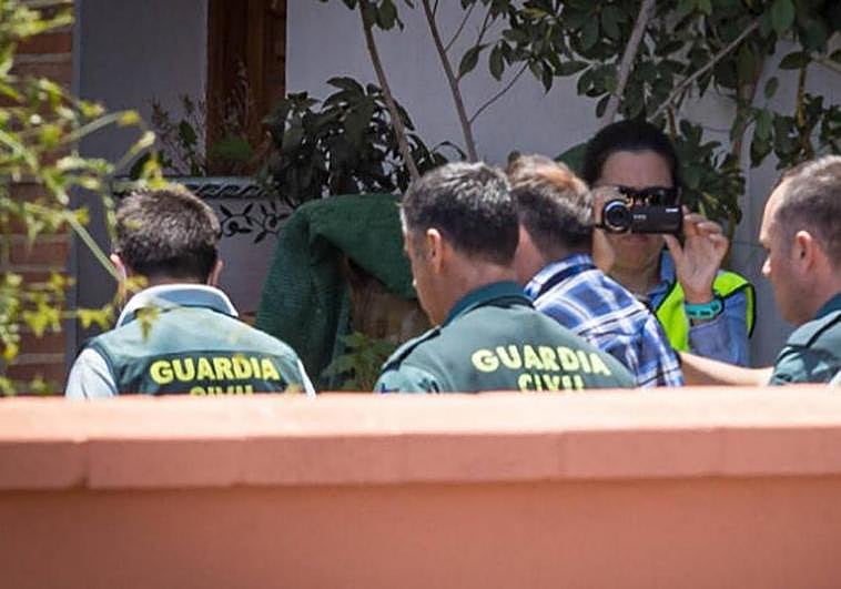 Guardias civiles conducen al detenido al interior de la vivienda para reconstruir el triple crimen.