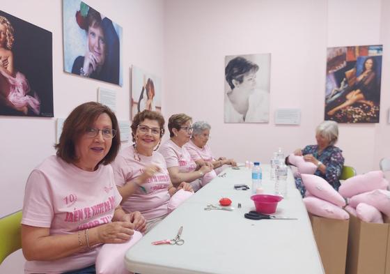 Voluntarias de AJICAM durante el maratón rematando el cojín en forma de corazón.