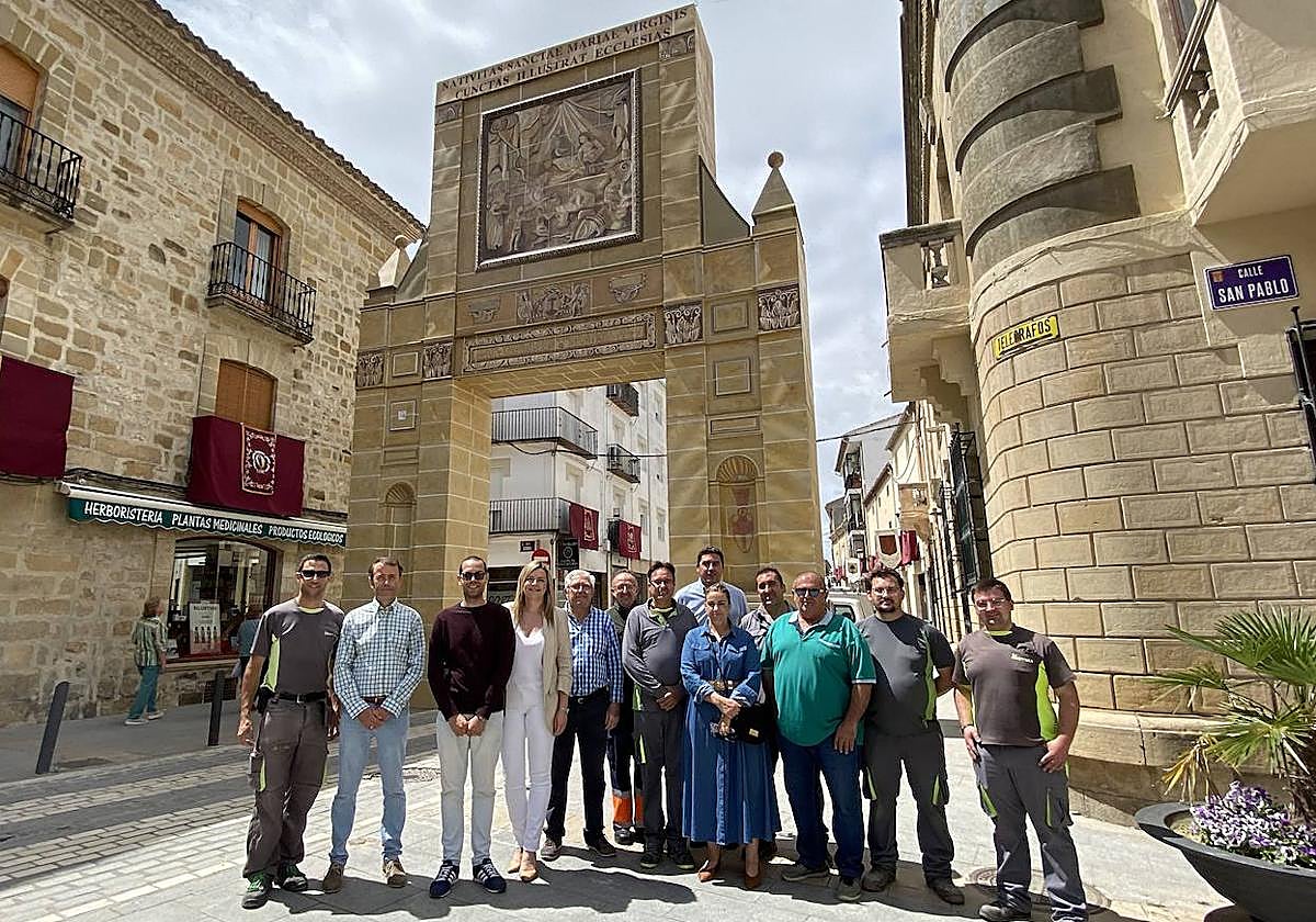 Foto de familia de miembros del ayuntamiento y responsables de la puerta ante el monumento.