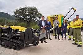 El consejero de la Presidencia, Antonio Sanz, junto al robot que incorpora esta temporada el Plan Infoca y que puede ser manejado a distancia.