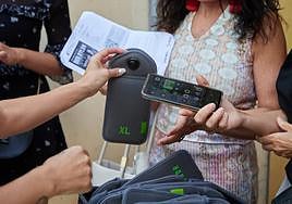 Una mujer deposita su móvil en una de las bolsas acolchadas, en el concierto de Bob Dylan en Granada.