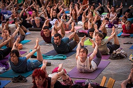 Praticantes de yoga hacen la postura del arco.