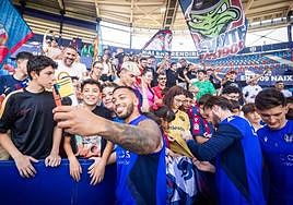Los futbolistas del Levante se fotografían con aficionados durante el entrenamiento a puerta abierta del viernes.