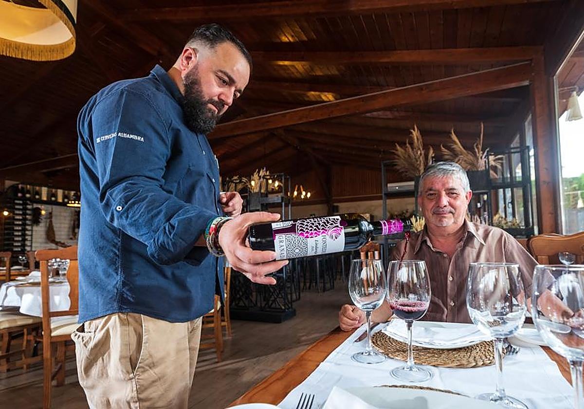 Juan Carlos Hita sirve un vino Fontedei a un cliente en su establecimiento de La Zubia.