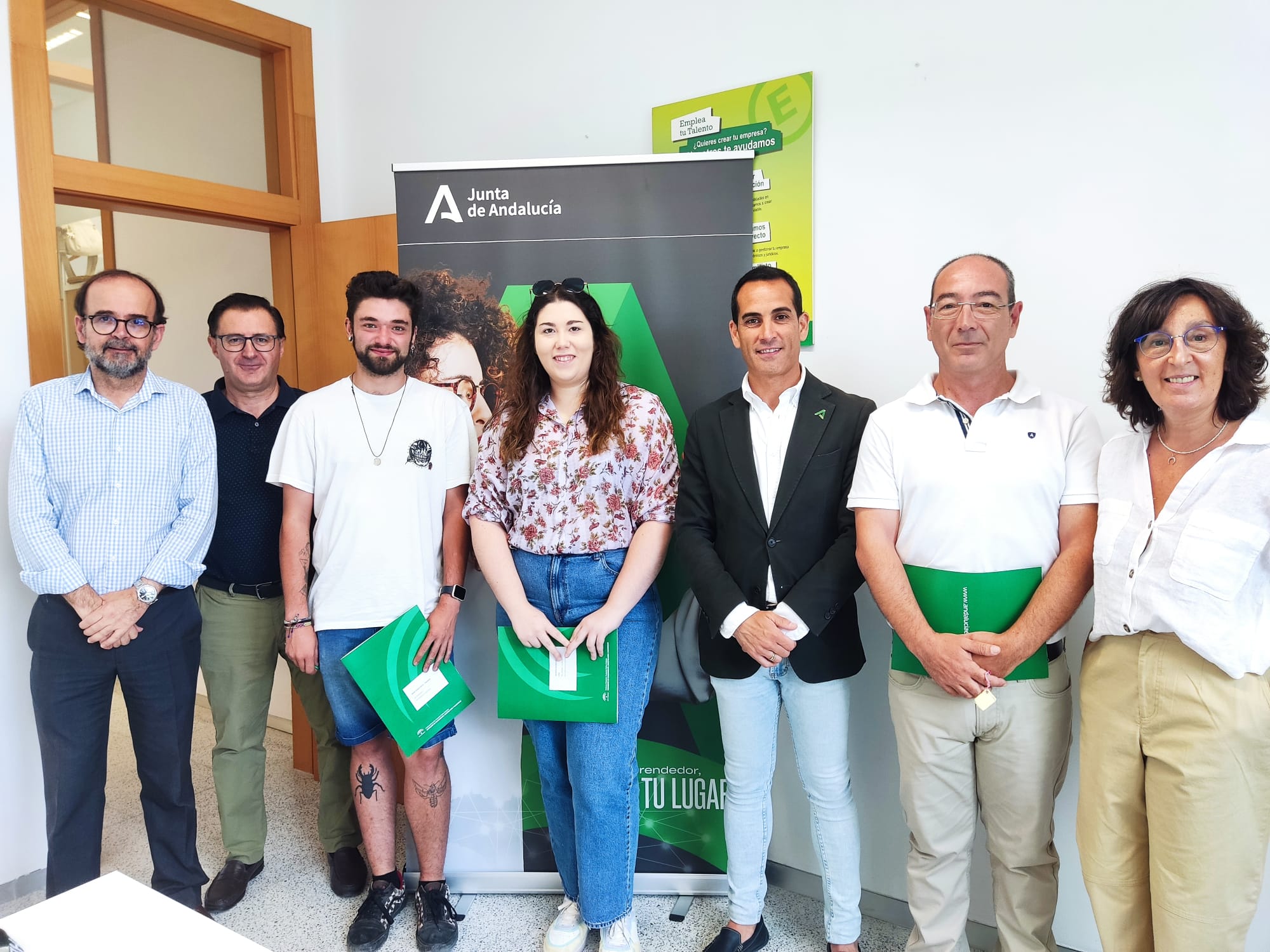 Los nuevos empresarios con las carpetas verdes entres sus manos posan con responsables del CADE.