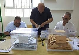 Los miembros de la mesa introducen el voto por correo en las urnas tras comprobar la inscripción de los electores.