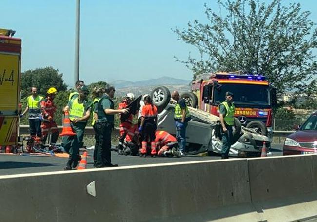 Bomberos tratan de rescatar al herido.