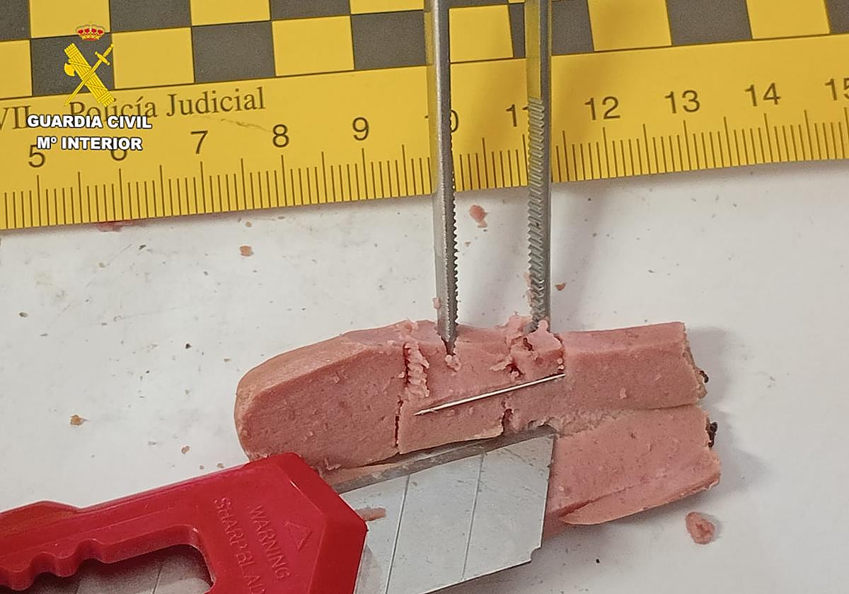 Uno de los trozos de salchhicas con alfileres.